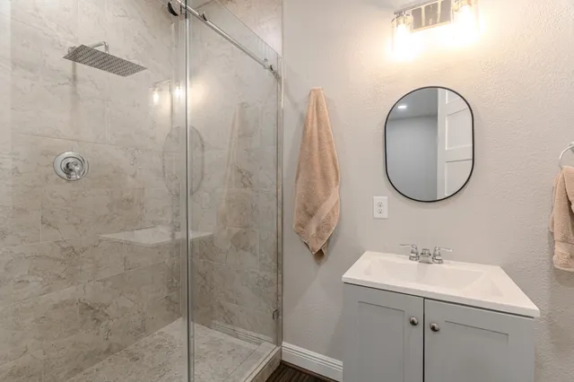 a bathroom with a sink a shower and a mirror
