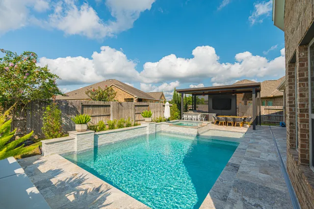 a view of a house with swimming pool and sitting area