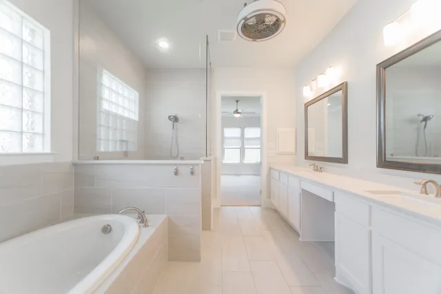 a spacious bathroom with a tub sink and mirror