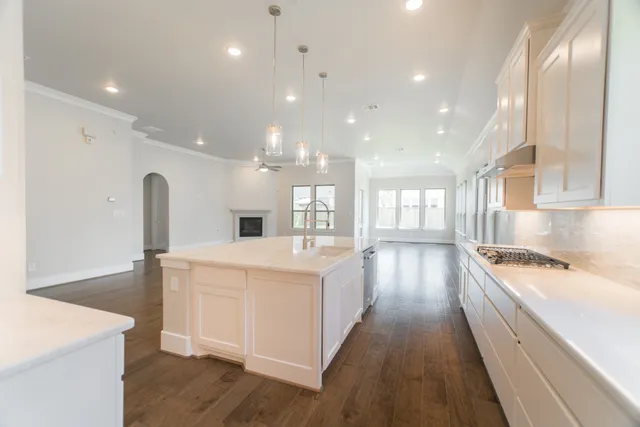 a kitchen with a sink stove and wooden floor