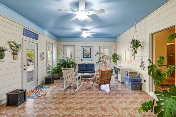 a living room with furniture a chandelier and a dining table