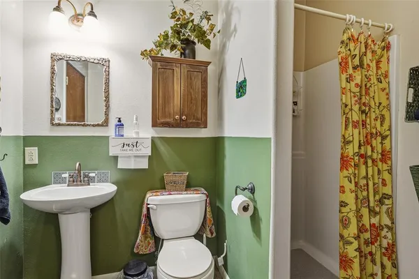 a bathroom with a sink toilet and mirror