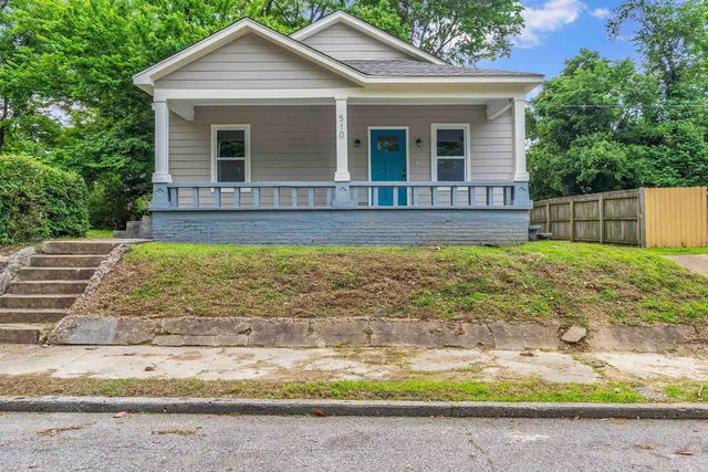 a view of a house with a yard and potted plants