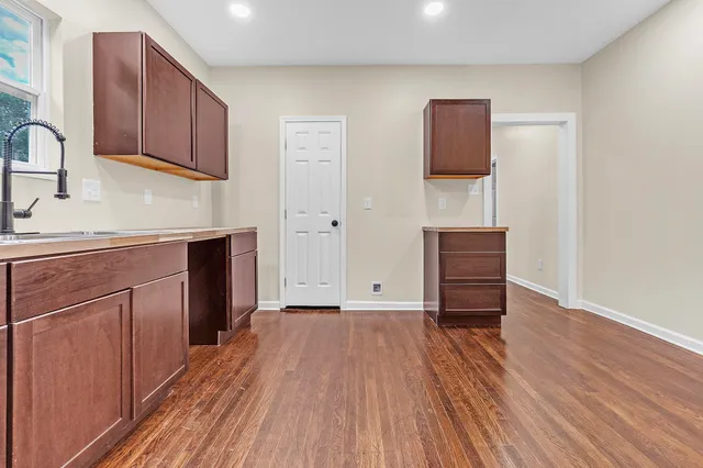 a view of a kitchen with cabinets and wooden floor