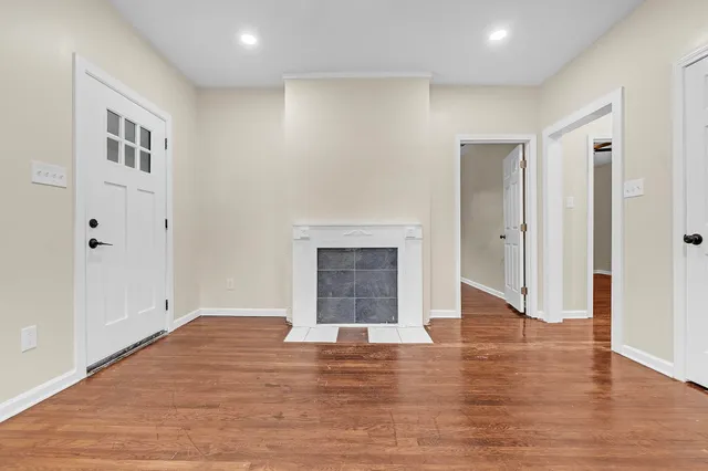 a view of an empty room with wooden floor