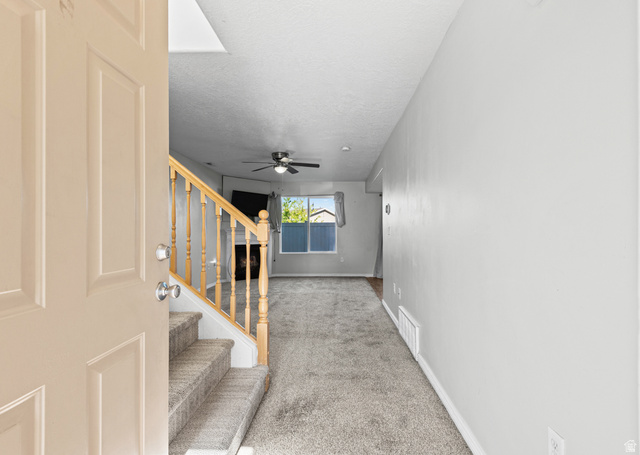 652 West 800 North, Unit 45 Clinton, UT 84015 - Photo 4 of 17 Entryway featuring a staircase with carpeted treads and natural wood banister