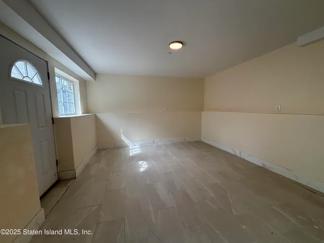 a view of a livingroom with an empty space and a window
