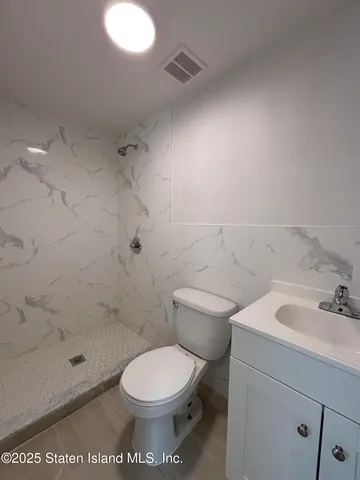 a white toilet sitting next to a bathroom sink