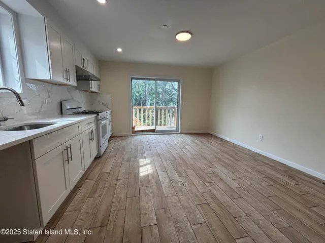 a kitchen with wooden floors and white cabinets