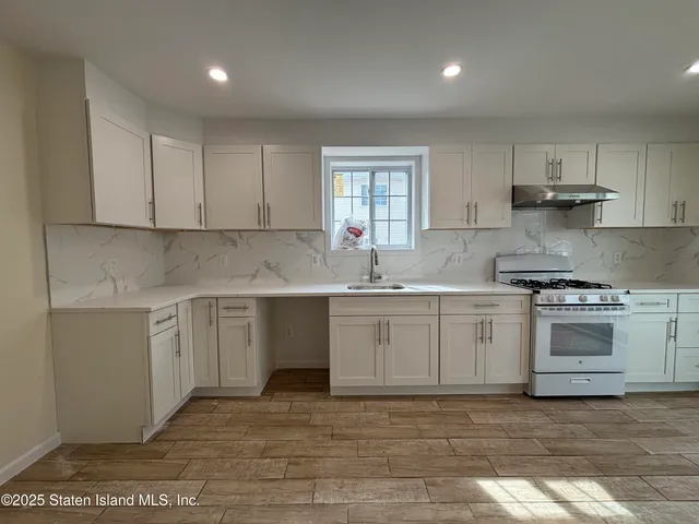 a kitchen with granite countertop a sink stainless steel appliances and cabinets
