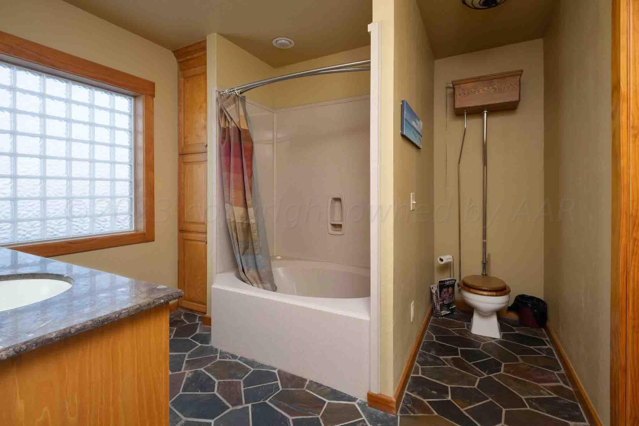 21401 Hope Road Canyon, TX 79015 - Photo 65 of 121 a bathroom with a granite countertop sink toilet and shower