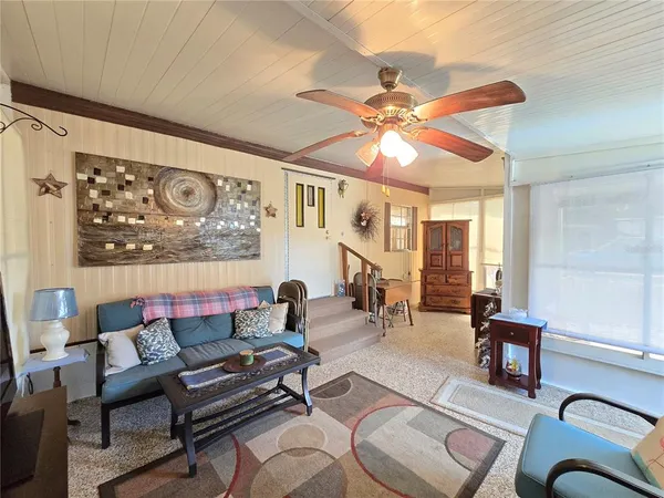 a living room with furniture a flat screen tv and a window