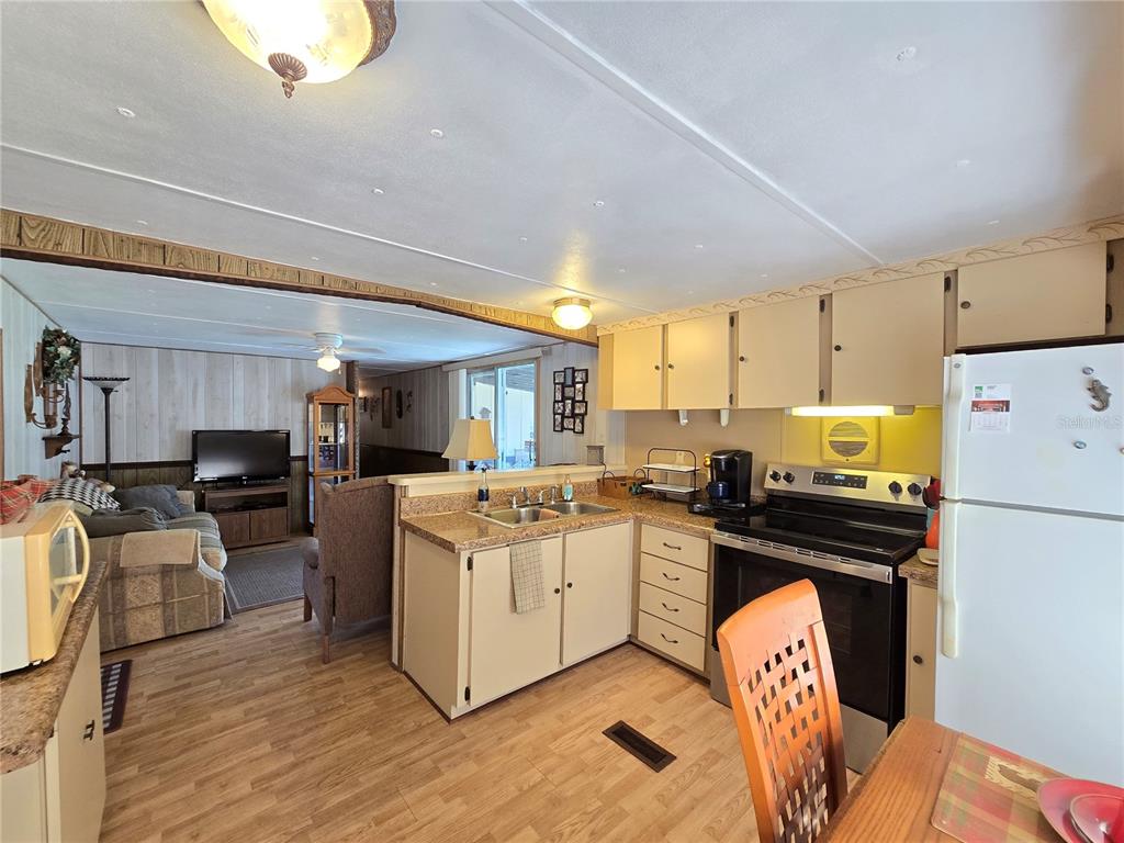 1621 Haddock Street St. Cloud, FL 34771 - Photo 27 of 46 a kitchen with stainless steel appliances kitchen island wooden floors stove and white cabinets