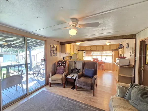 a living room with furniture a flat screen tv and a large window