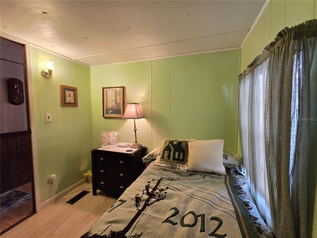 1621 Haddock Street St. Cloud, FL 34771 - Photo 34 of 46 a bedroom with a bed and wooden floor