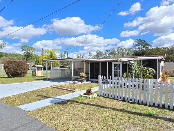 a view of a house with a small yard and wooden fence