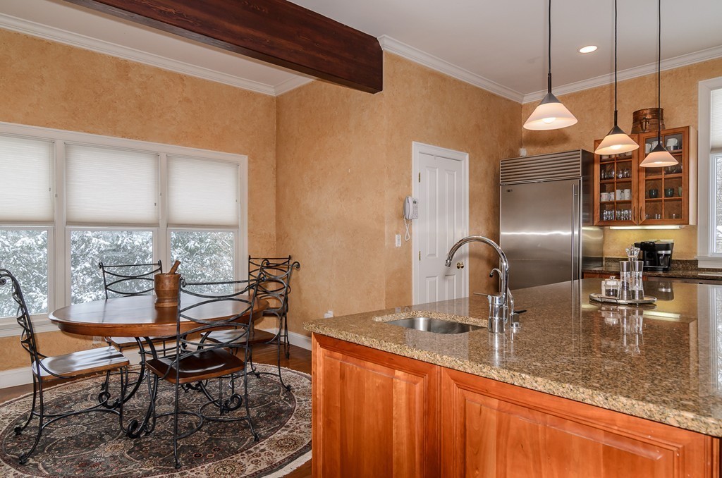 5 Wareland Road Wellesley, MA 02481 - Photo 9 of 19 a kitchen with stainless steel appliances granite countertop a sink wooden cabinets dining table and chairs
