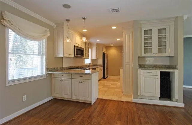 a large kitchen with cabinets wooden floor and a sink