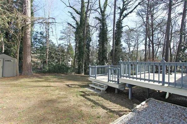 a view of a wooden deck with chairs and a yard
