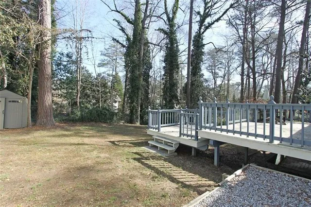 a view of a wooden deck with chairs and a yard