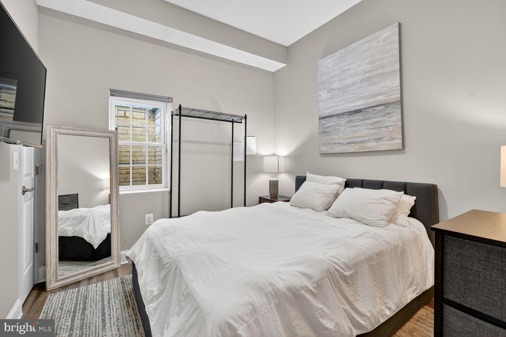 133 7th Street Southeast, Unit 3 Washington, DC 20003 - Photo 12 of 19 a bedroom with a bed and wooden floor