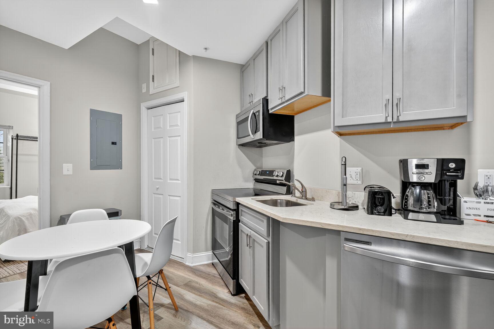 133 7th Street Southeast, Unit 3 Washington, DC 20003 - Photo 7 of 19 a kitchen with stainless steel appliances granite countertop a sink a stove and white cabinets