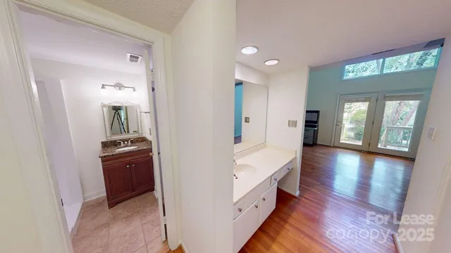 a view of a hallway with wooden floor and windows