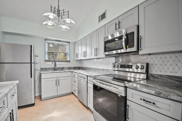 a kitchen with white cabinets and stainless steel appliances