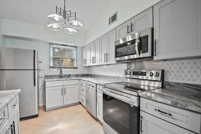 a kitchen with white cabinets and stainless steel appliances