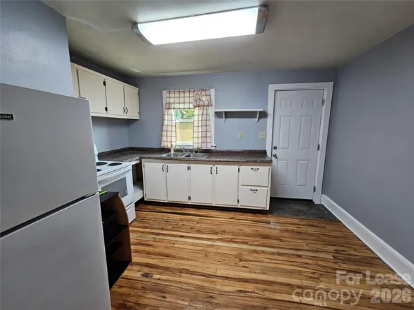 a kitchen with granite countertop a sink cabinets stainless steel appliances and a window