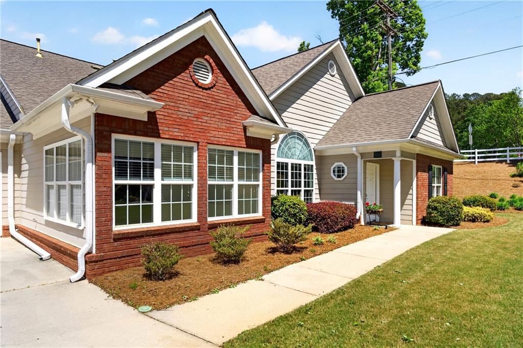 a front view of a house with a yard and outdoor seating