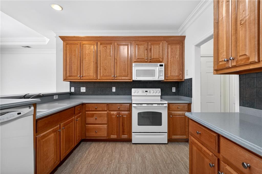 226 Hames Road, Unit 140 Woodstock, GA 30188 - Photo 14 of 32 a kitchen with stainless steel appliances granite countertop a stove a sink and a microwave