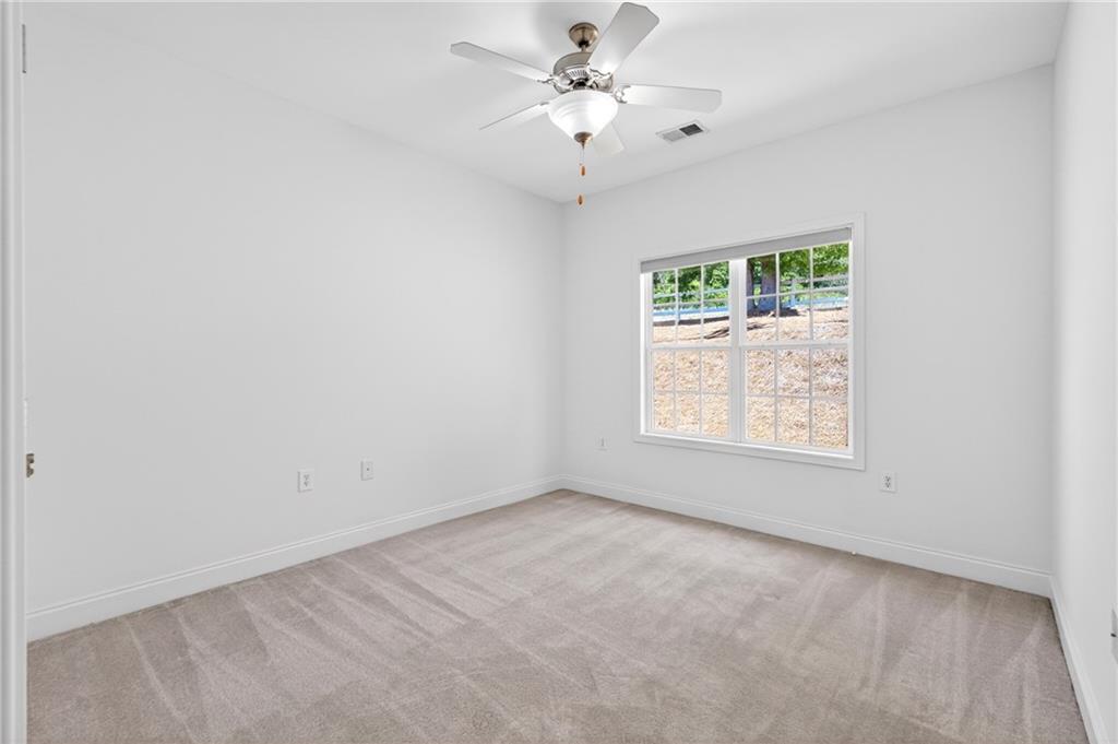 226 Hames Road, Unit 140 Woodstock, GA 30188 - Photo 25 of 32 an empty room with windows and ceiling fan