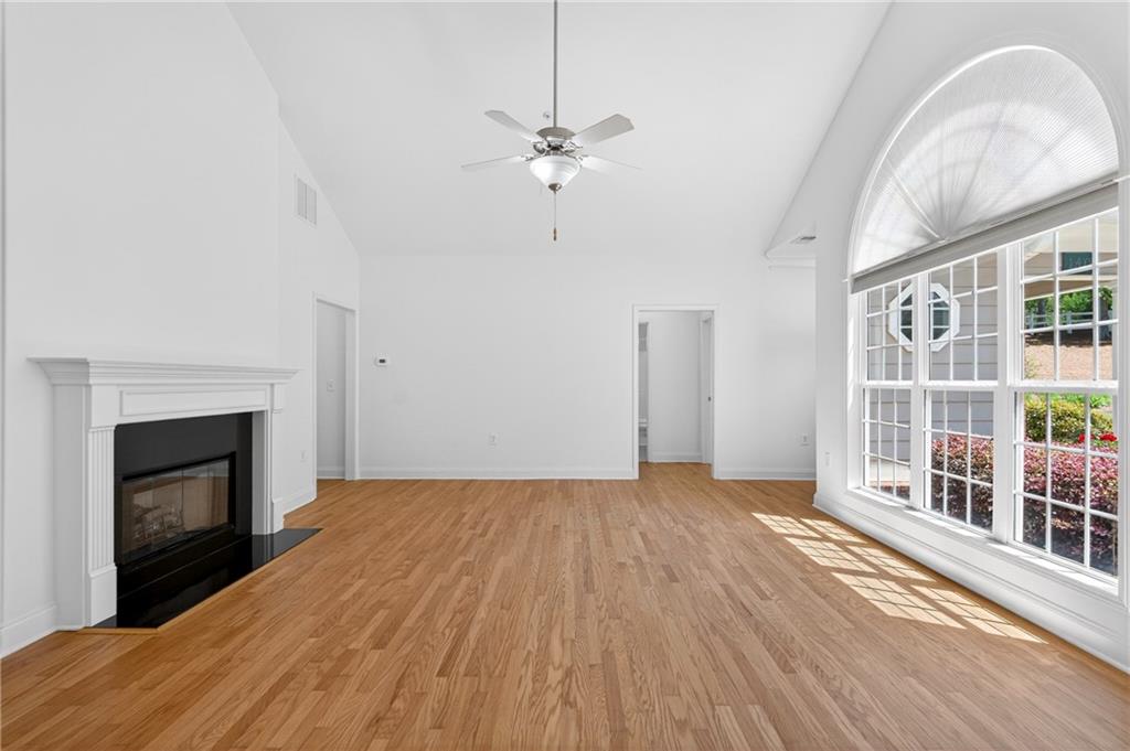 226 Hames Road, Unit 140 Woodstock, GA 30188 - Photo 6 of 32 an empty room with wooden floor fireplace and windows