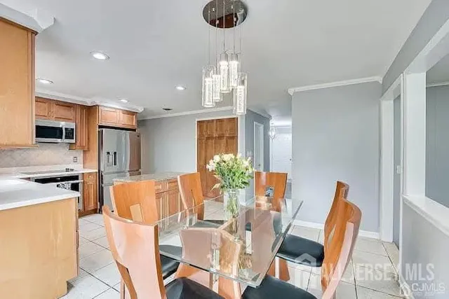a dining room with furniture a chandelier and kitchen view