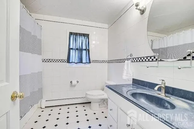 a bathroom with a granite countertop sink a toilet and shower