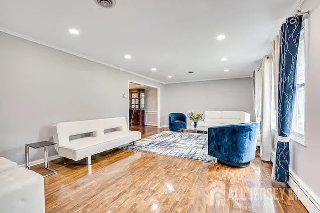 a living room with furniture and a wooden floor