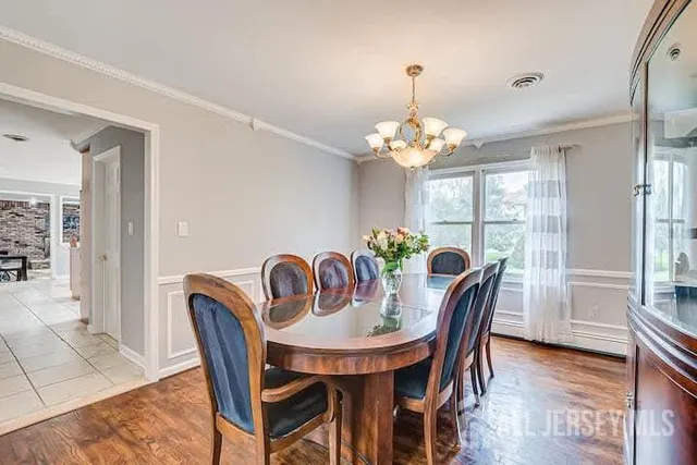 a dining room with furniture a chandelier and wooden floor