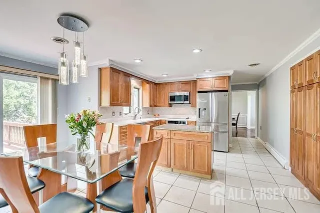 a dining room with stainless steel appliances kitchen island granite countertop a table and chairs in it
