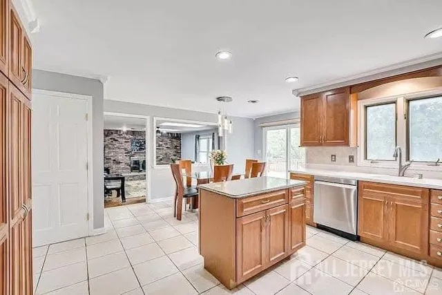 a kitchen that has a lot of white cabinets and stainless steel appliances