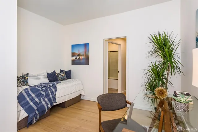 a bedroom with a large bed and a potted plant