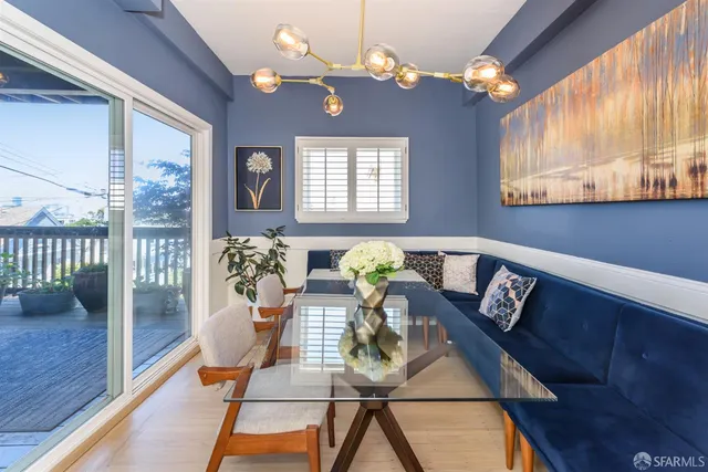 a view of a dining room with furniture a chandelier and wooden floor