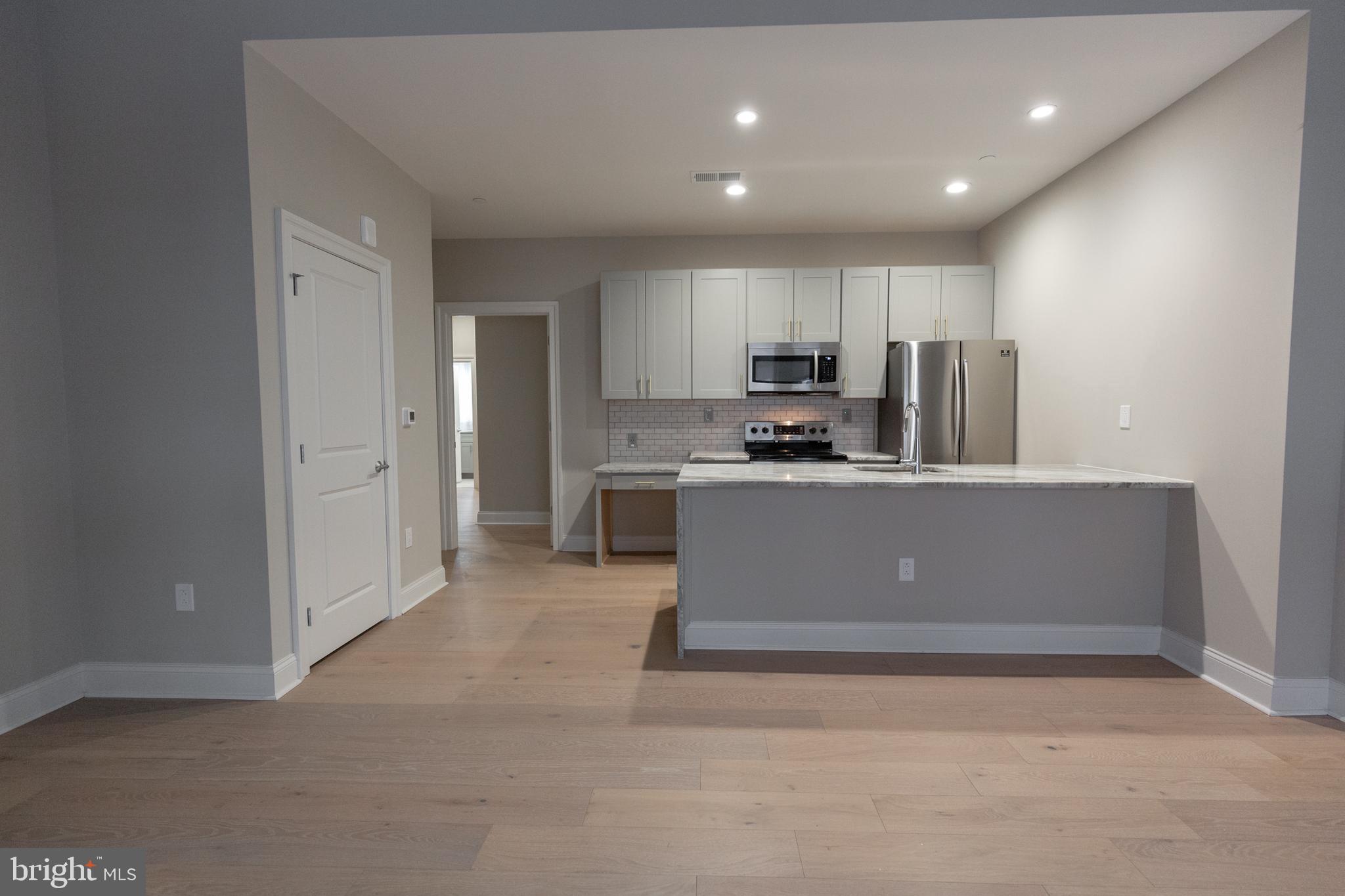 1411-1 Walnut Street, Unit 201 Philadelphia, PA 19102 - Photo 15 of 27 a kitchen with stainless steel appliances a refrigerator sink and microwave