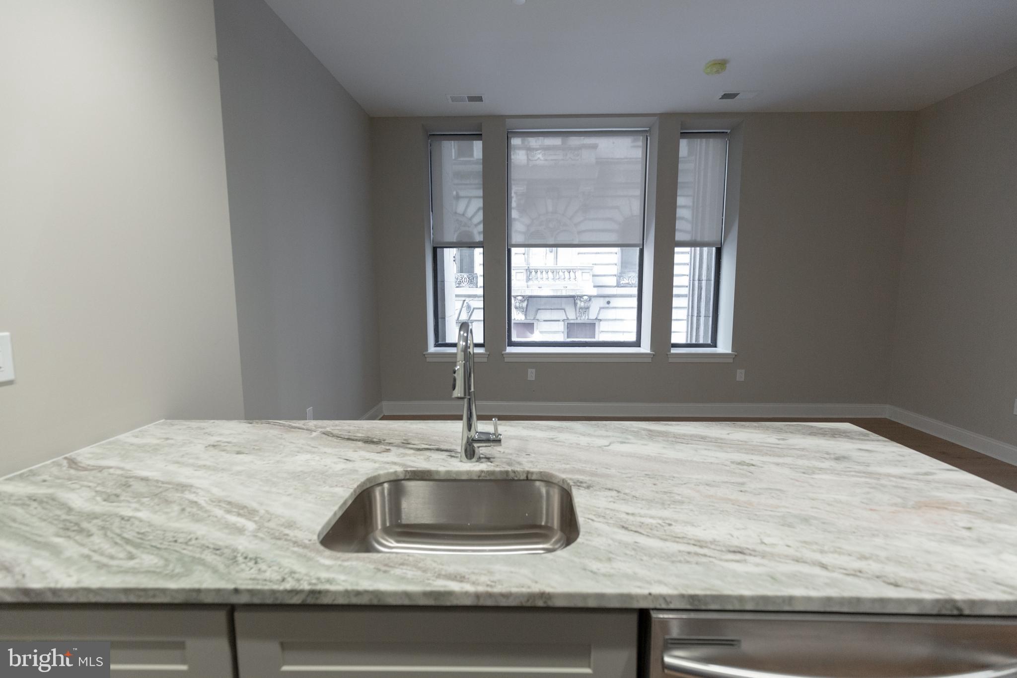 1411-1 Walnut Street, Unit 201 Philadelphia, PA 19102 - Photo 9 of 27 a kitchen with granite countertop a sink and a window