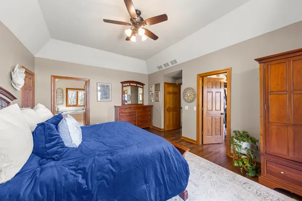 a bedroom with a large bed and a chandelier