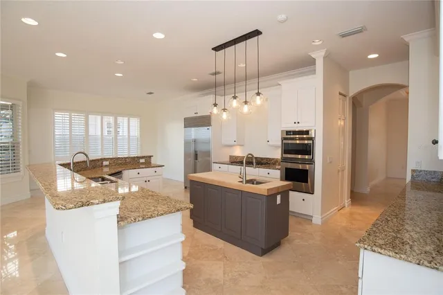 a kitchen with granite countertop a sink a counter top space appliances and cabinets