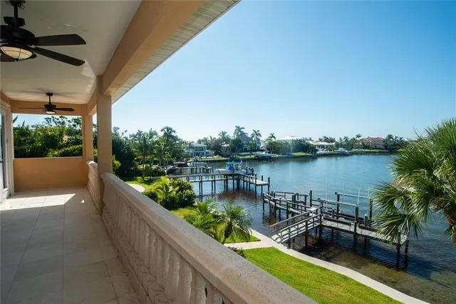 a view of a lake from a balcony with outdoor seating