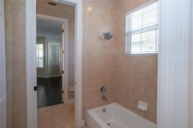 a bathroom with a tub shower and a window