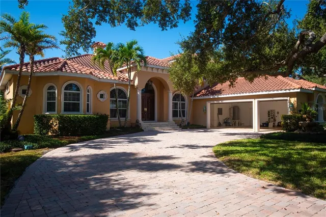 a front view of a house with a garden and trees