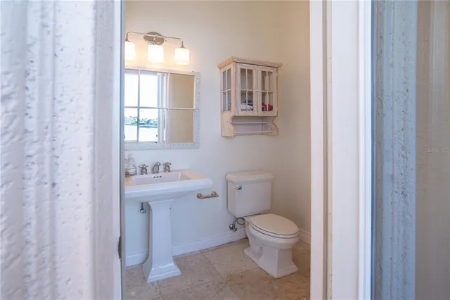 a bathroom with a toilet a sink and a window